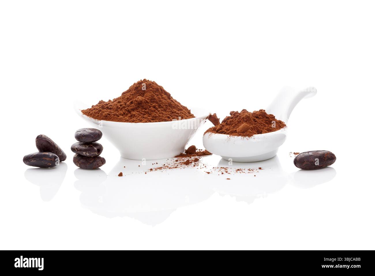 Fagioli di cacao e cacao in polvere in recipiente bianco e cucchiaio bianco su sfondo bianco. Supercibo sano Foto Stock