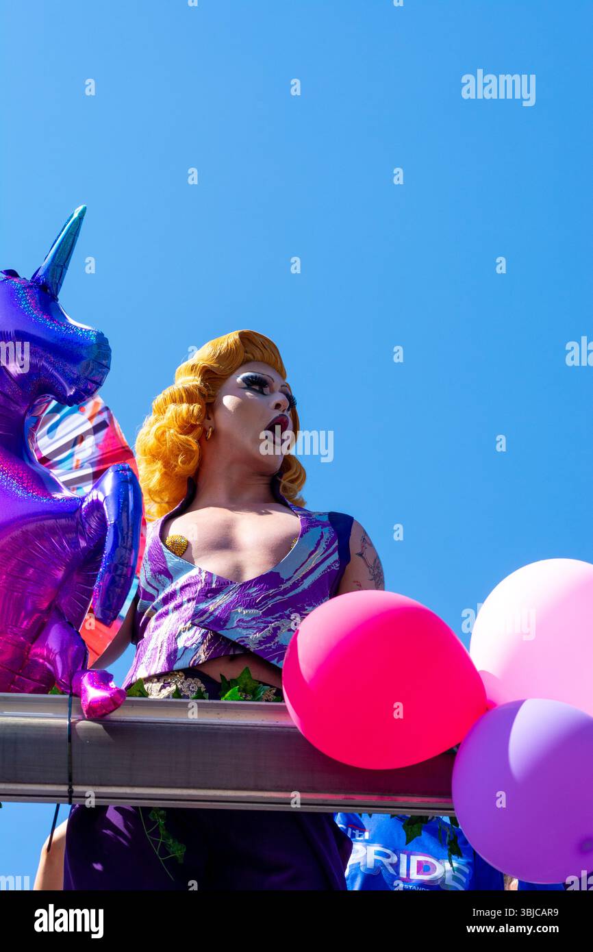 Una drag queen si esibisce tra palloni arcobaleno e un pallone unicorno alla Parade Równości in via Nowy Świat a Varsavia, Polonia, giugno 2025. Foto Stock
