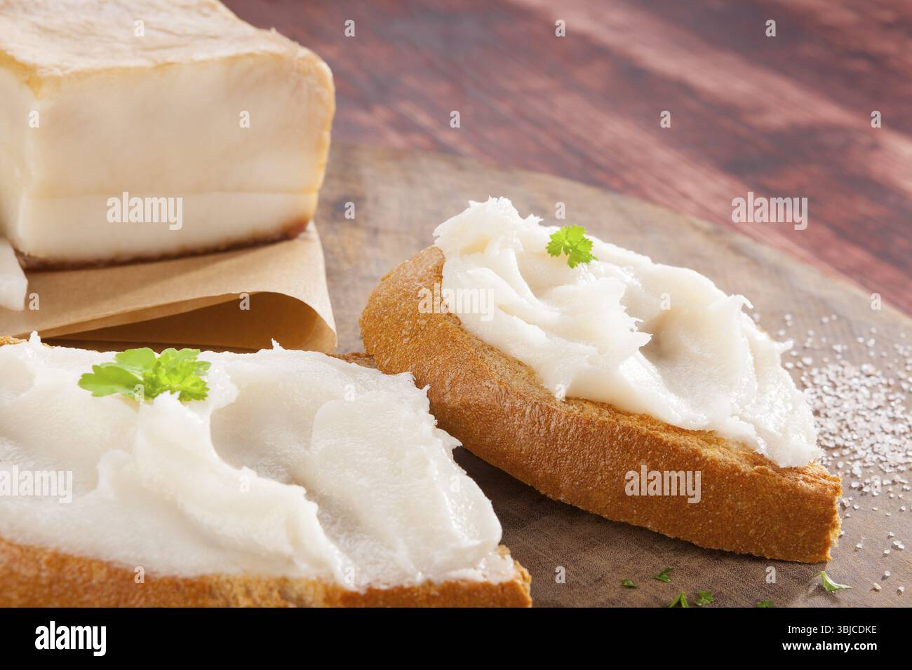 Cucina tradizionale dell'europa orientale. Fetta di pane con strutto e pancetta su fondo in legno, stile rustico rustico rustico Foto Stock