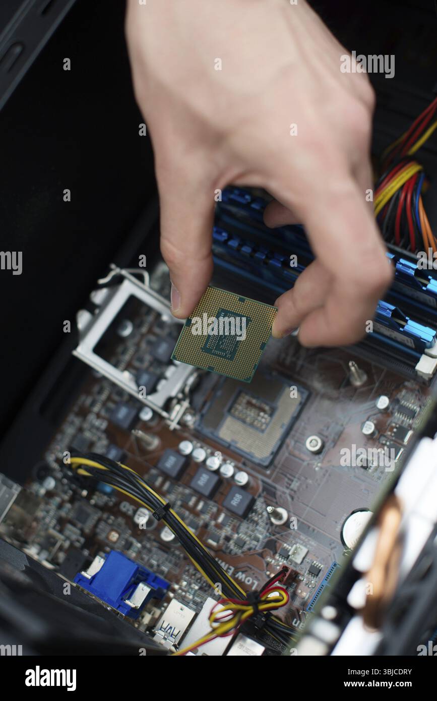 Tecnico informatico che installa la CPU nella scheda madre Foto Stock