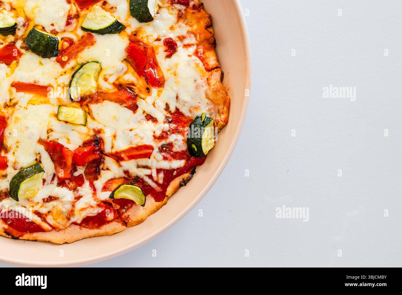 una sana pizza vegetariana preparata con zucchine, capsicum e base di lenticchie rosse, che presenta cibo rustico fatto in casa e mangiare pulito in un sano e piccolo Foto Stock una sana pizza vegetariana preparata con zucchine, capsicum e base di lenticchie rosse, che presenta cibo rustico fatto in casa e mangiare pulito in un sano e piccolo Foto Stock