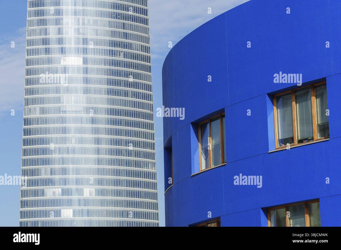 Grattacielo e edificio blu con facciate in vetro in un ambiente urbano, Bilbao, Paesi Baschi, Spagna, Europa Foto Stock