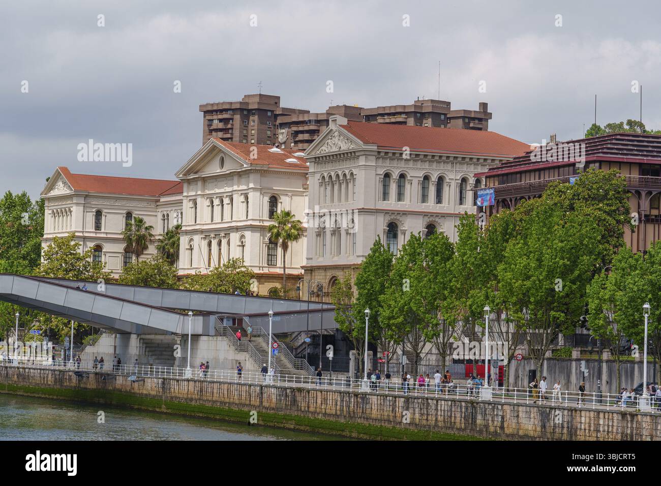 Edifici classici lungo una riva del fiume con alberi verdi, Bilbao, Paesi Baschi, Spagna, Europa Foto Stock