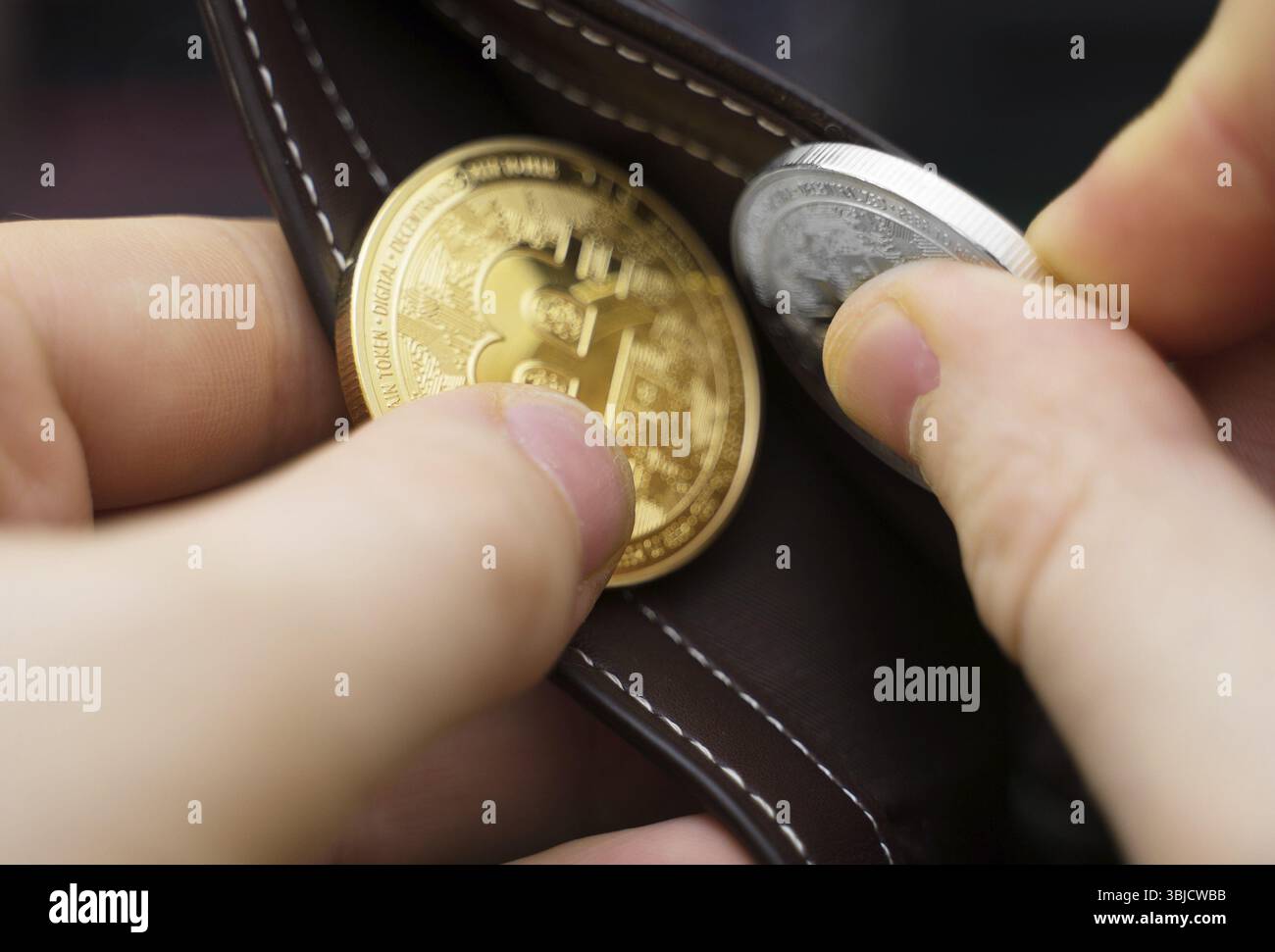 Uomo con versione fisica di bitcoin d'oro e d'argento Foto Stock
