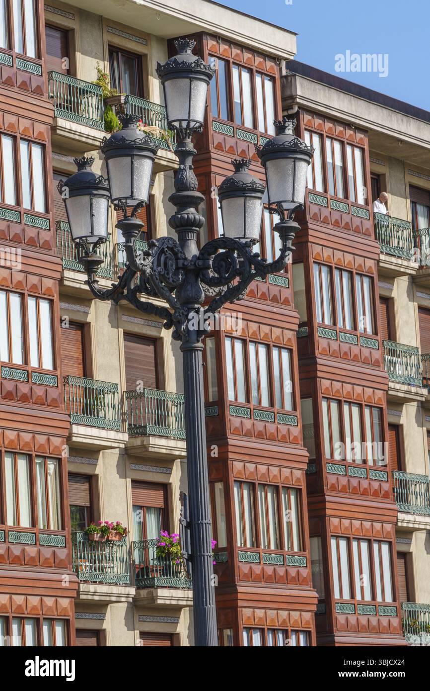 Lampione storico di fronte a un edificio residenziale con cornici rosse per finestre, Bilbao, Paesi Baschi, Spagna, Europa Foto Stock