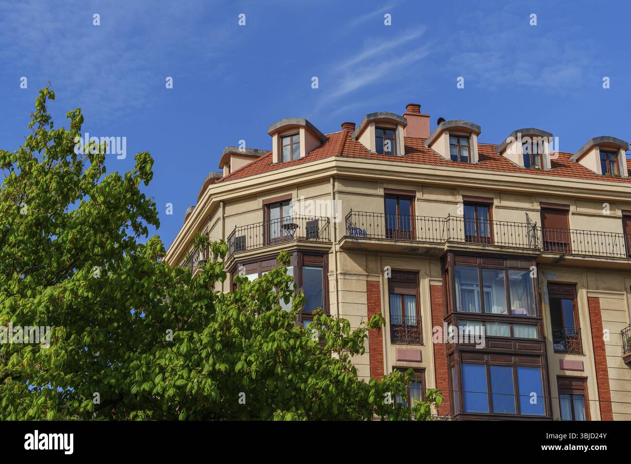 Un edificio carismatico con balconi e alberi verdi in primo piano, Bilbao, Paesi Baschi, Spagna, Europa Foto Stock