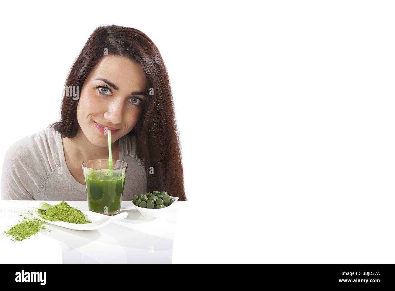 Disintossicazione. Bella ragazza con bevanda verde in mano isolata su bianco. Spirulina, clorella e erba graminacea. Stile di vita sano, disintossicazione Foto Stock