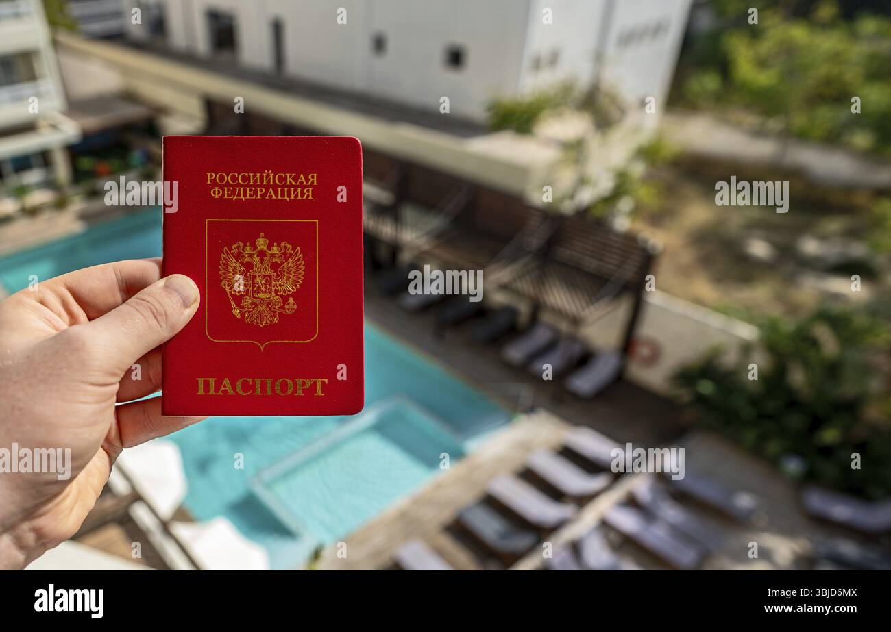 Uomo con passaporto russo sullo sfondo di un hotel di lusso Foto Stock