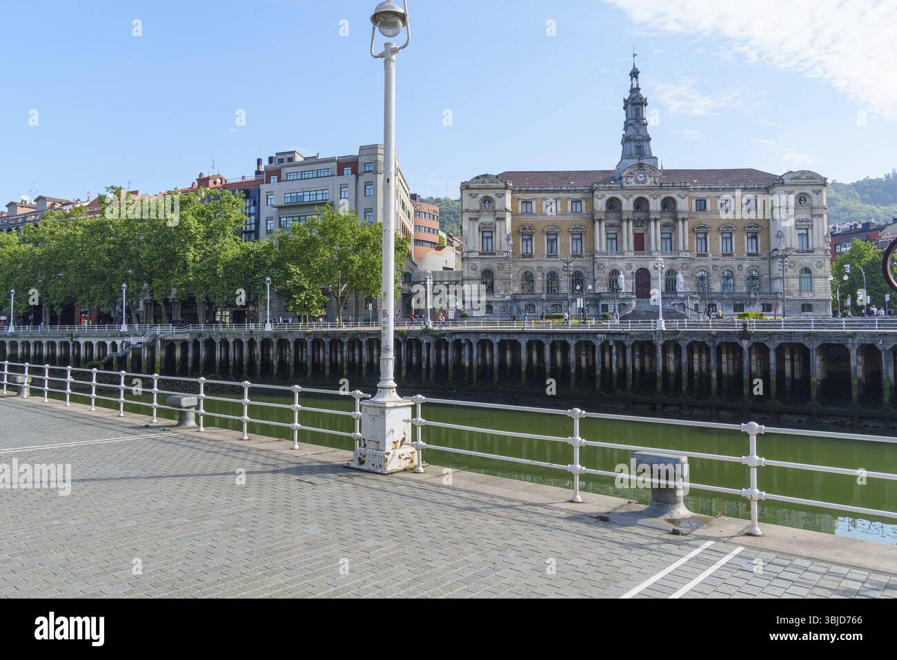 Passeggiata sul fiume con passaggio pedonale, edificio storico e cielo blu, Bilbao, Paesi Baschi, Spagna, Europa Foto Stock