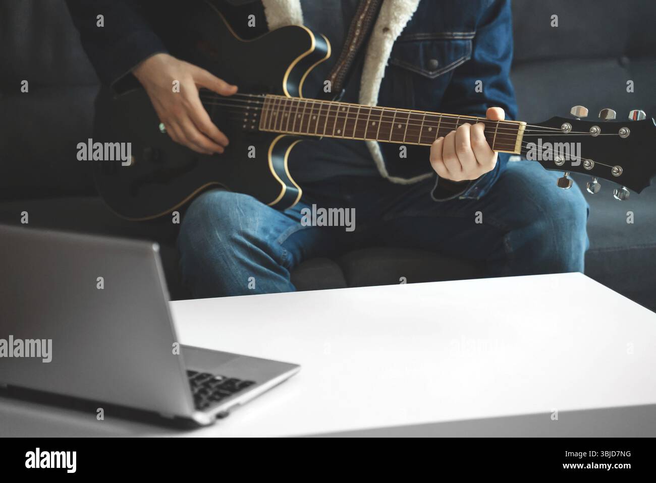 L'insegnante mostra come suonare la chitarra. Lezione online remota Foto Stock