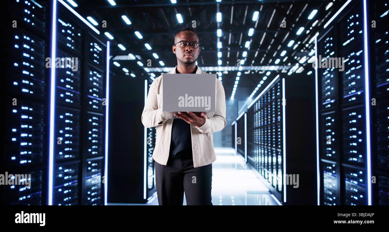 Afroamericano Data Engineer configura Server rack nel data center. Foto Stock