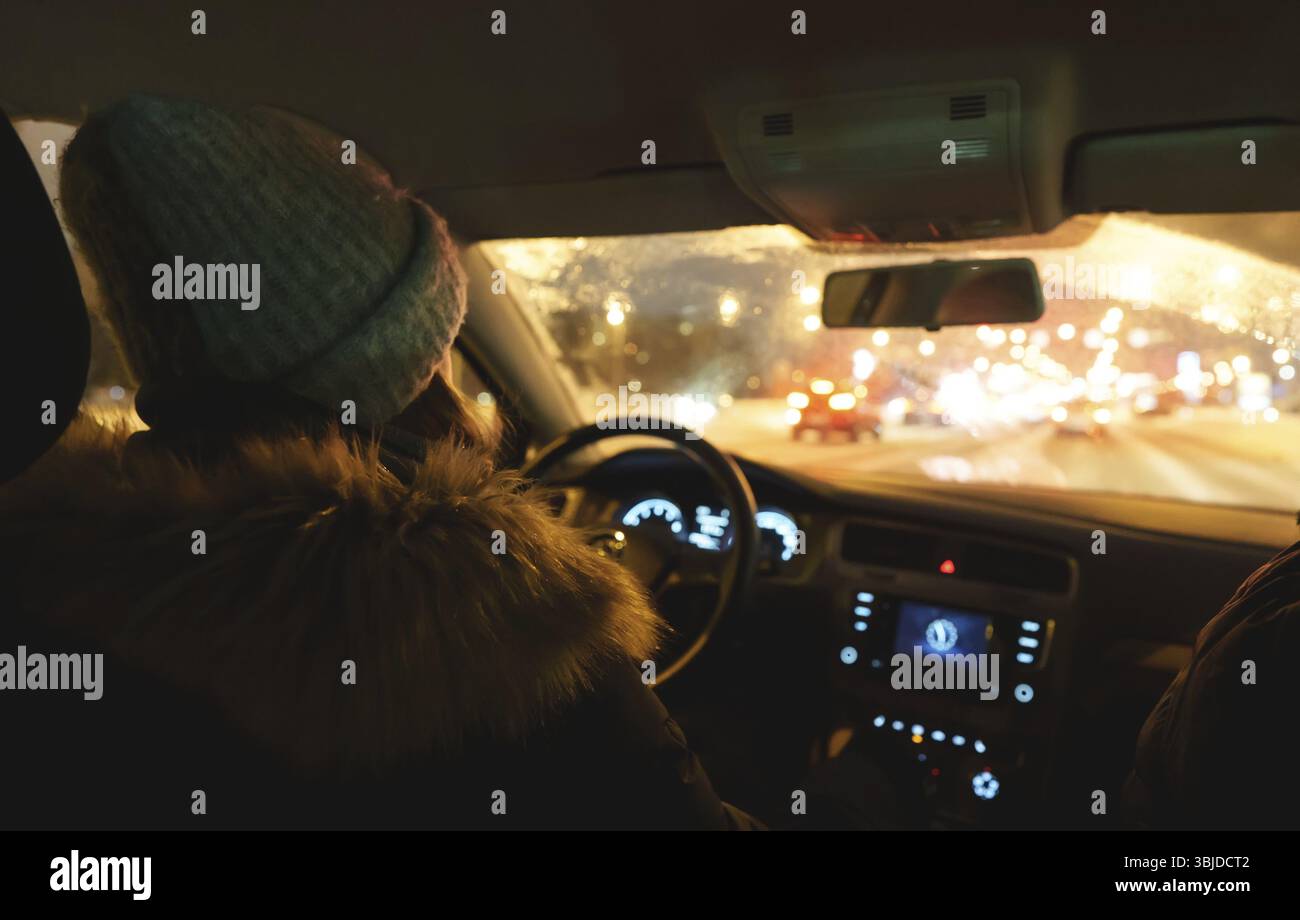 Donna che guida un'auto in inverno Foto Stock