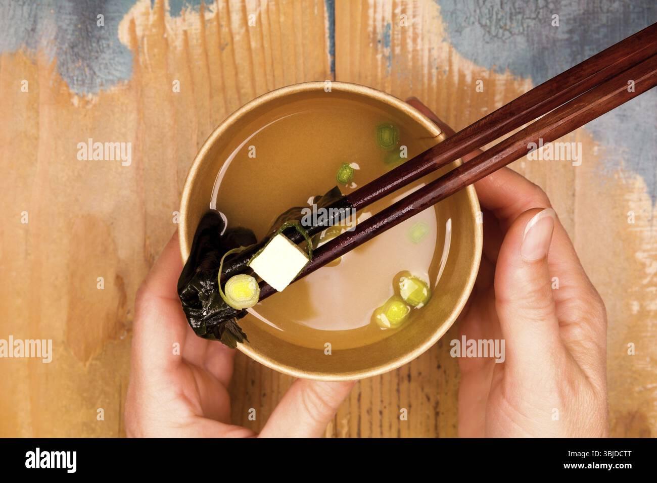 Donna che tiene una tazza da asporto con zuppa di miso. Cucina tradizionale asiatica Foto Stock