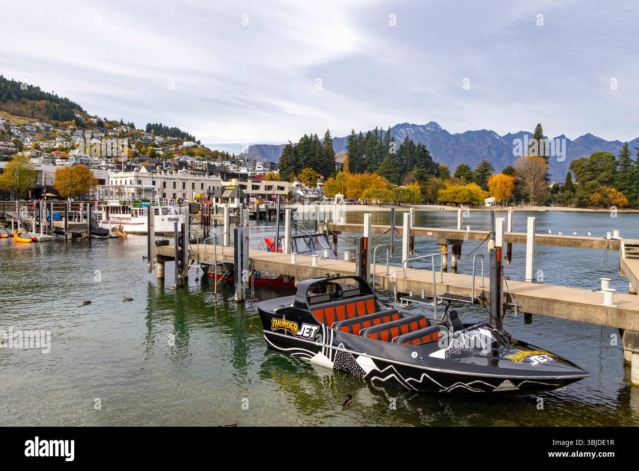 Motoscafo veloce Thunder ormeggiato sul Lago Wakatipu con vista sul lungolago di Queenstown e sul centro citta', Otago, Isola del Sud, nuova Zelanda Foto Stock