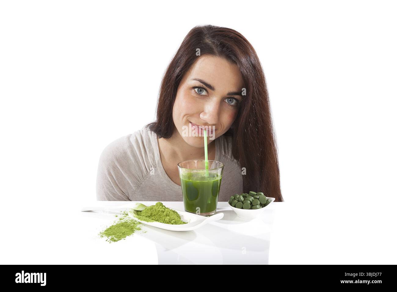 Disintossicazione. Bella ragazza con bevanda verde in mano isolata su bianco. Spirulina, clorella e erba graminacea. Stile di vita sano, disintossicazione Foto Stock