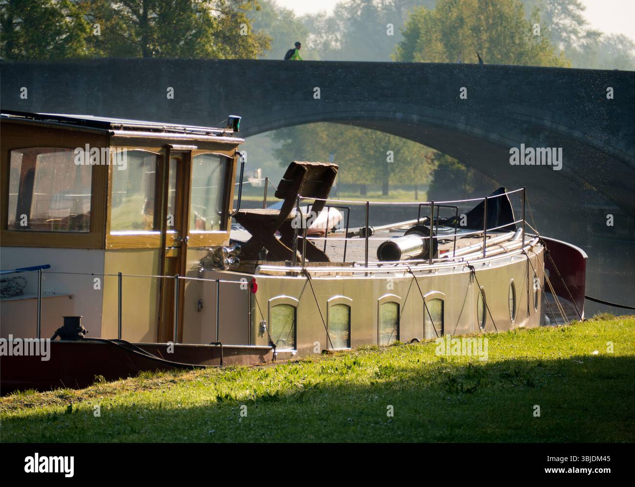 Casa galleggiante ormeggiata sul Tamigi ad Abingdon, in una bella mattinata sputata. Si trova proprio accanto al ponte medievale di pietra di Abingdon, la cui campata principale può essere Foto Stock