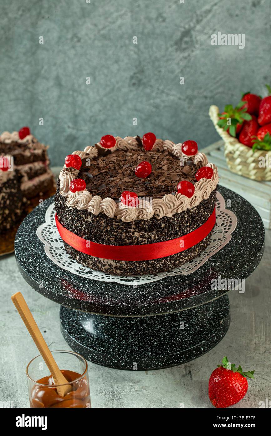 Torta della Foresta Nera con ricchi strati di cioccolato e ciliegie, dessert occidentale premium. Foto Stock