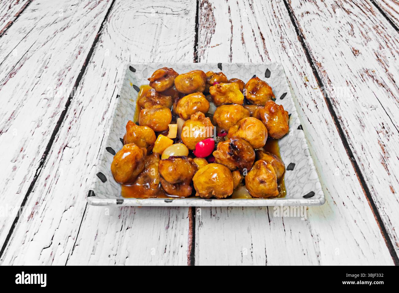 sapore più acido e meno dolce, e il maiale non viene sempre impanato allo stesso modo. Foto Stock