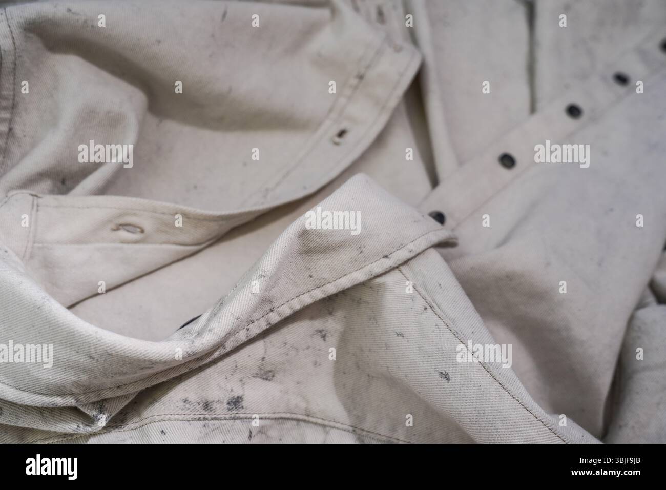 Primo piano di camicia in tessuto beige chiaro con motivo a macchie e dettagli sui bottoni Foto Stock