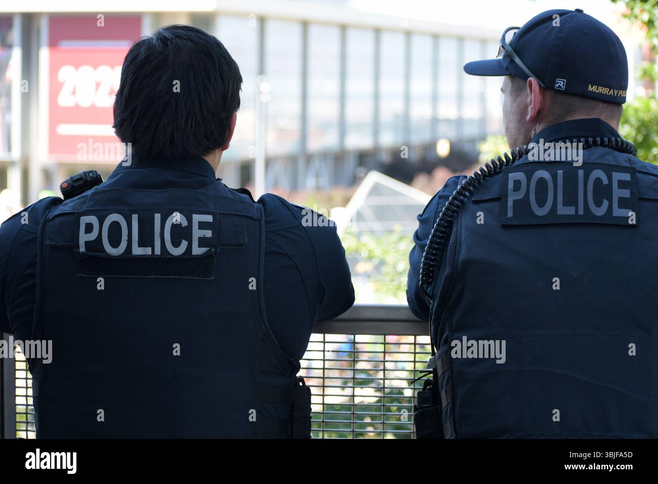 SALT LAKE CITY, UTAH – 15 GIUGNO 2025: Due agenti di polizia sorvegliano la folla alla protesta "No Kings", garantendo la sicurezza all'Università dello Utah. Foto Stock
