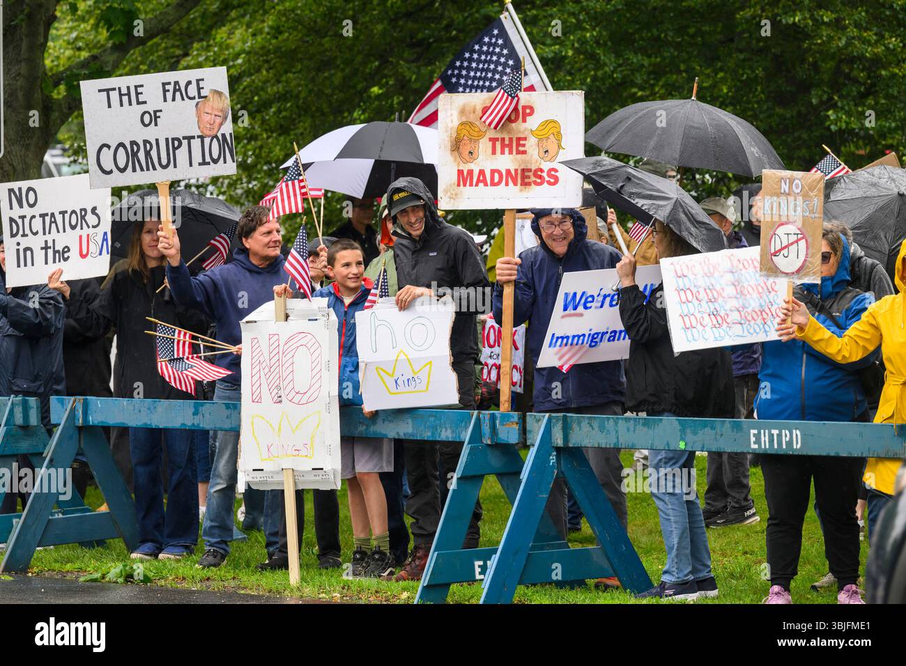 Partecipanti a una protesta del "No Kings" Day tenutasi di fronte all'East Hampton Town Hall a East Hampton, il 14 giugno 2025. La protesta faceva parte di una giornata nazionale di azione contro il presidente Donald Trump e le sue politiche. Gordon M. Grant/Alamy Foto Stock
