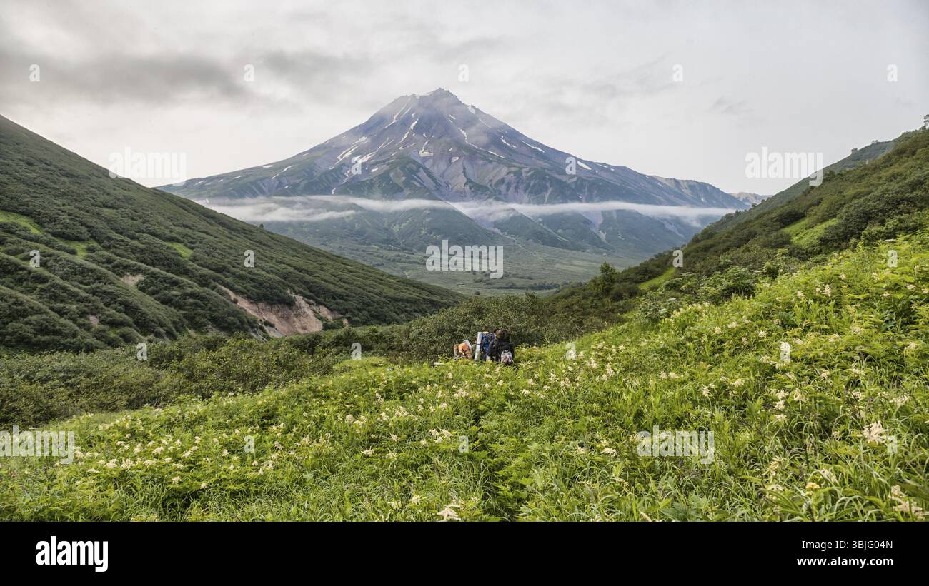 Montagne e vulcani. Lo splendido paesaggio della penisola di Kamchatka: estate vista panoramica della gamma della montagna Vachkazhets, lago di montagna e le nuvole in Foto Stock