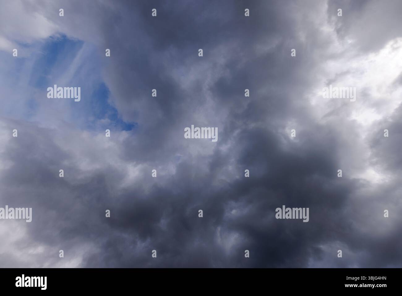 Nuvole cirrostrati grigie che coprono quasi tutto il cielo, piccolo scorcio di cielo blu dietro le nuvole, Finlandia Foto Stock
