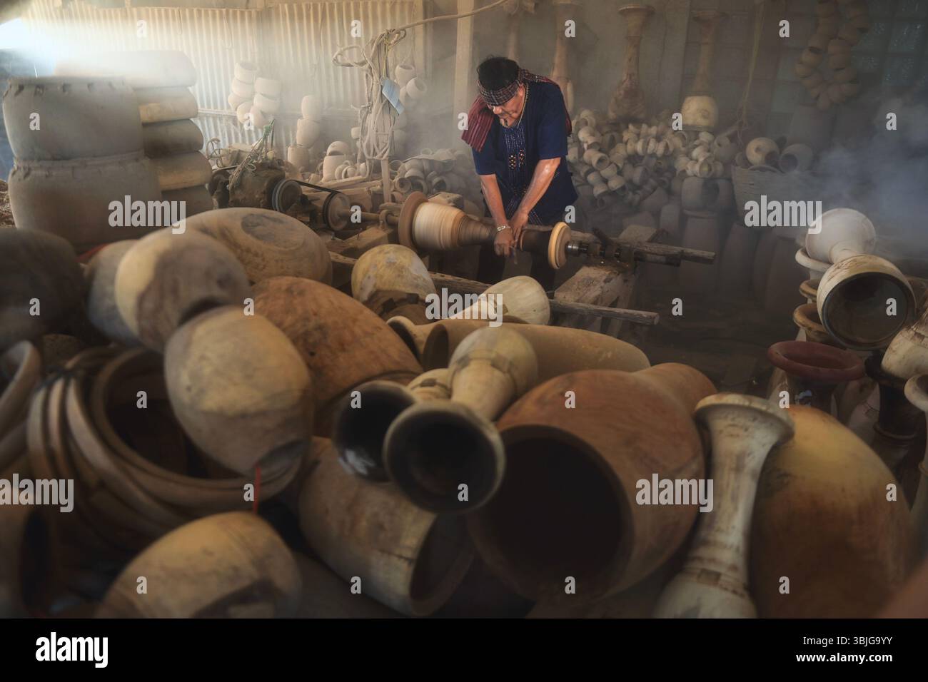 Primo piano di vasai maschili che producono vasi di terracotta in un laboratorio, la Thailandia Foto Stock