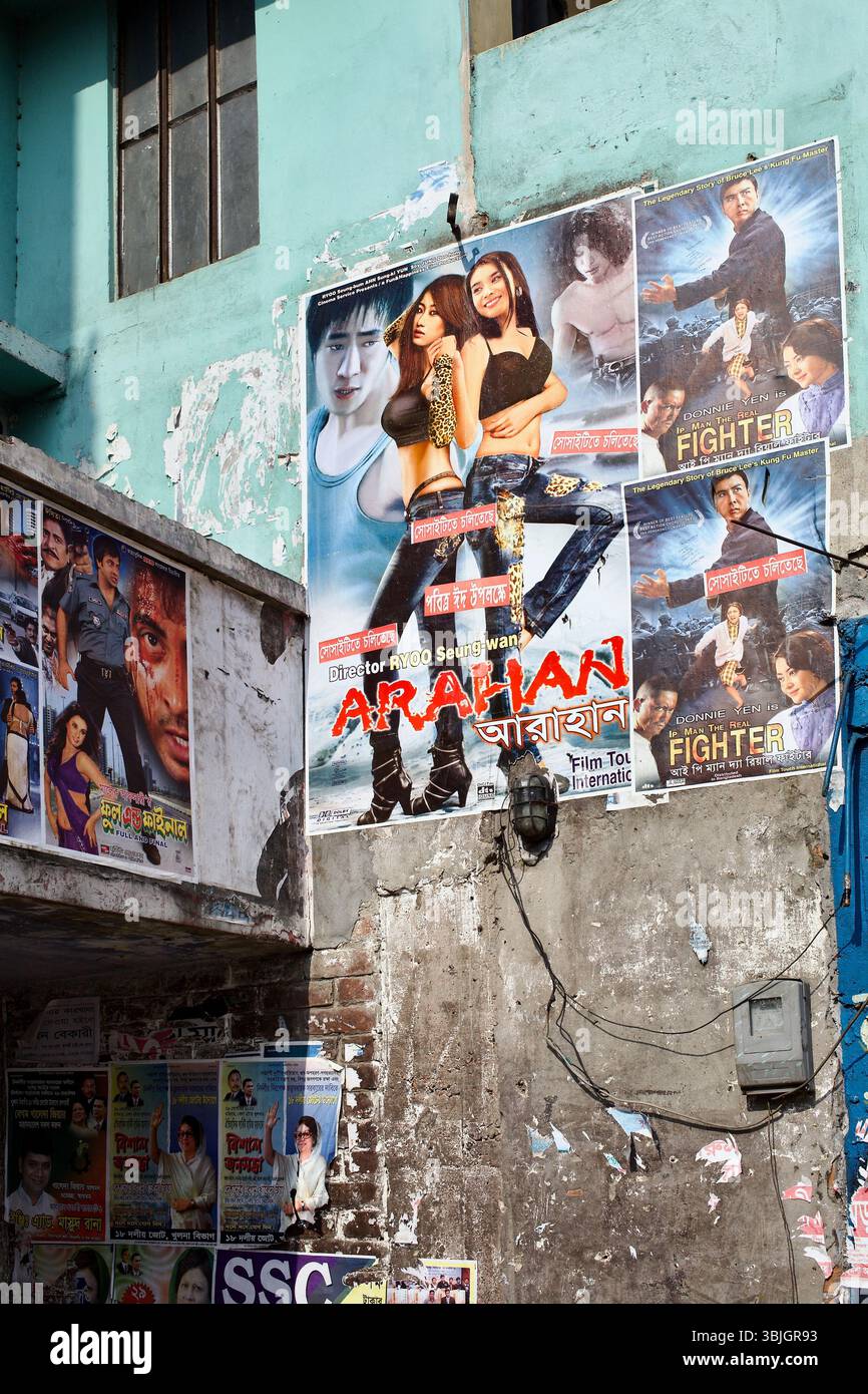 La fantasia d'azione sudcoreana Arahan pubblicizzata su un muro del cinema a Bagerhat, in Bangladesh, insieme a poster locali e importati in esposizione pubblica. Foto Stock
