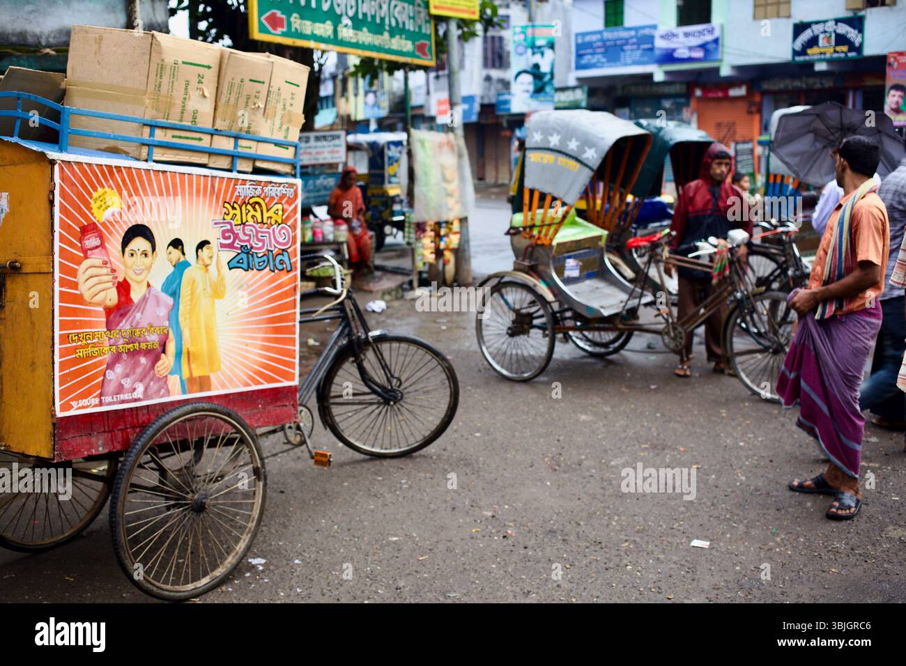 La pubblicità satirica dipinta a mano in Jessore collega la pulizia del bagno a salvare matrimoni, visto su un carrello di venditori tra risciò e vita di strada. Foto Stock