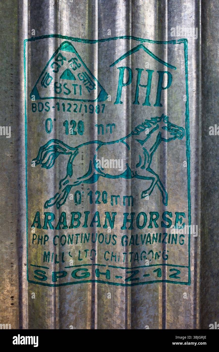 Lamiera zincata ondulata a marchio Arabian Horse su un muro di casa a Gattia, Kushtia, Bangladesh, realizzata da PHP Steel Mills a Chittagong. Foto Stock