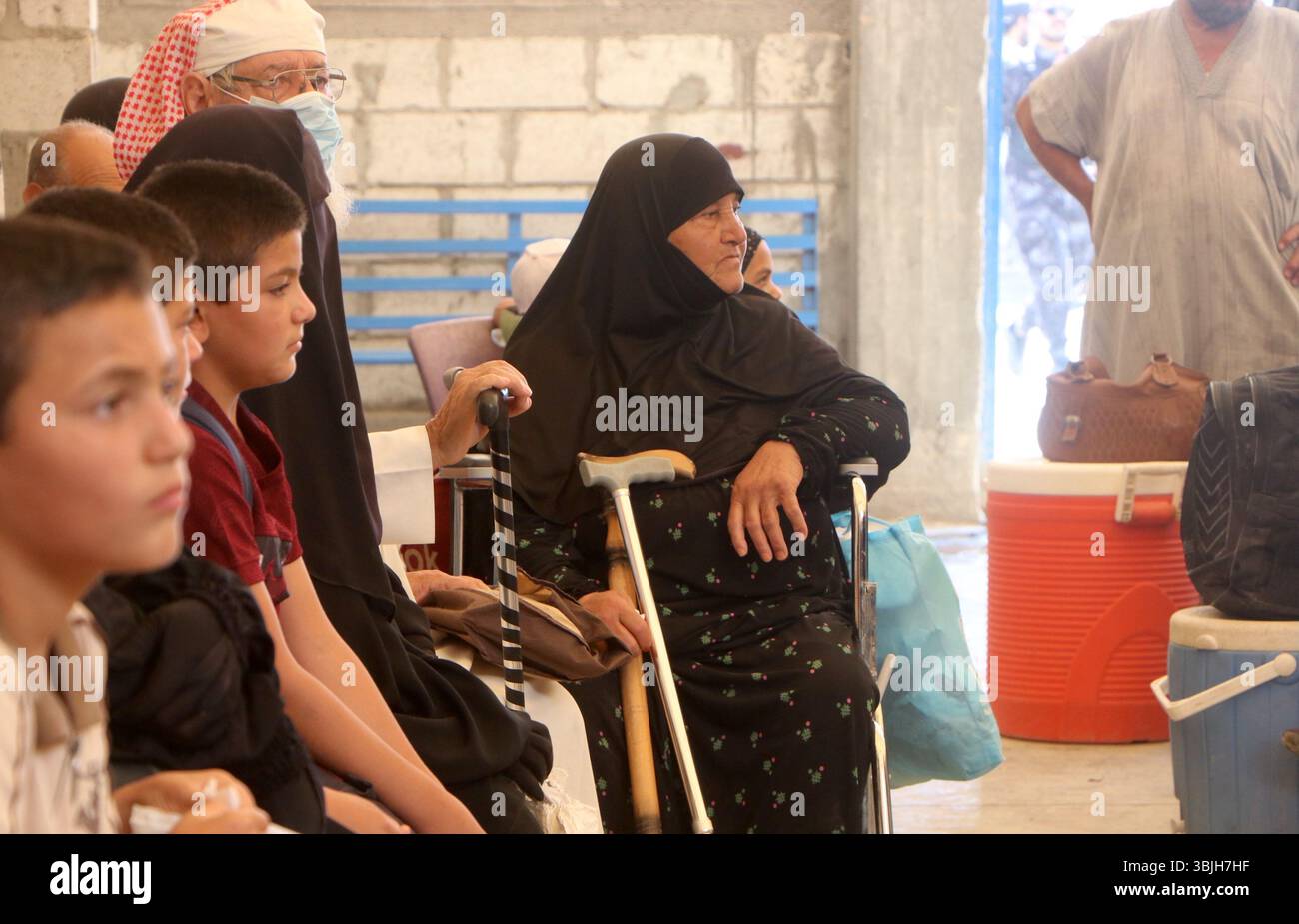 Al Hasakah. 16 giugno 2025. Anziani e giovani sfollati si riuniscono all'interno del campo di al-Hol mentre gli autobus si preparano a spostare le famiglie fuori di qui, nella provincia nord-orientale della Siria, al-Hasakah, il 15 giugno 2025. Decine di famiglie siriane sfollate hanno lasciato il famigerato campo di al-Hol nella Siria nord-orientale domenica, in un trasferimento umanitario coordinato tra l'amministrazione autonoma curda e il governo ad interim siriano, confermato da un coordinatore. Crediti: Str/Xinhua/Alamy Live News Foto Stock