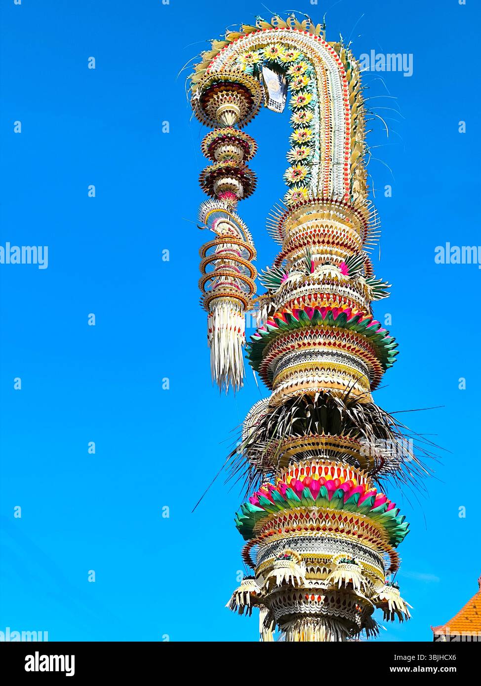 Denpasar, Bali, Indonesia, 16 maggio 2025: Grandi decorazioni Penjor si ergono sul lato della strada nell'area di Denpasar, Bali, con ornamenti realizzati Foto Stock