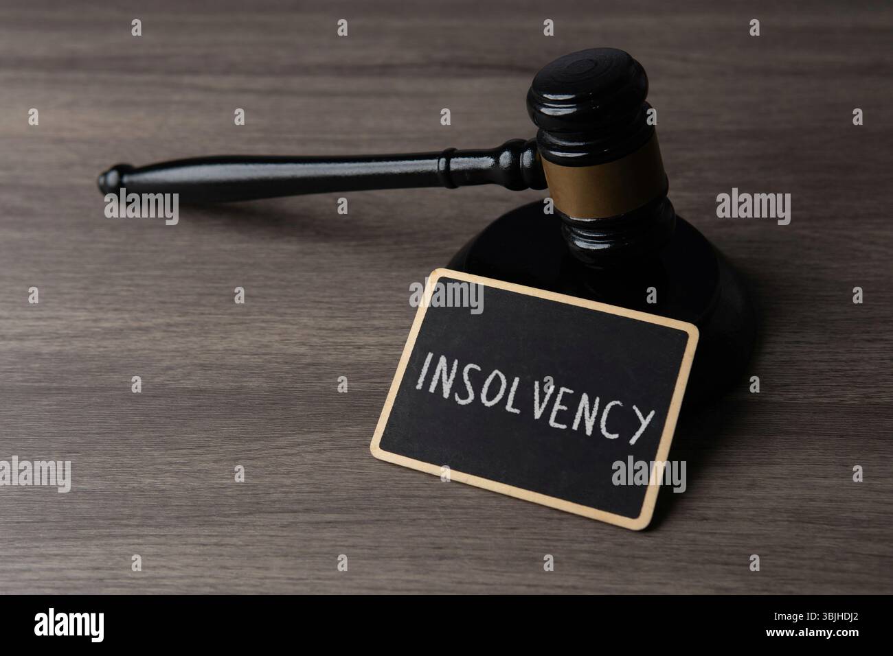 Un martelletto di un giudice e una lavagna con testo INSOLVENZA. Procedure legali, regolamenti finanziari e concetto di fallimento. Foto Stock