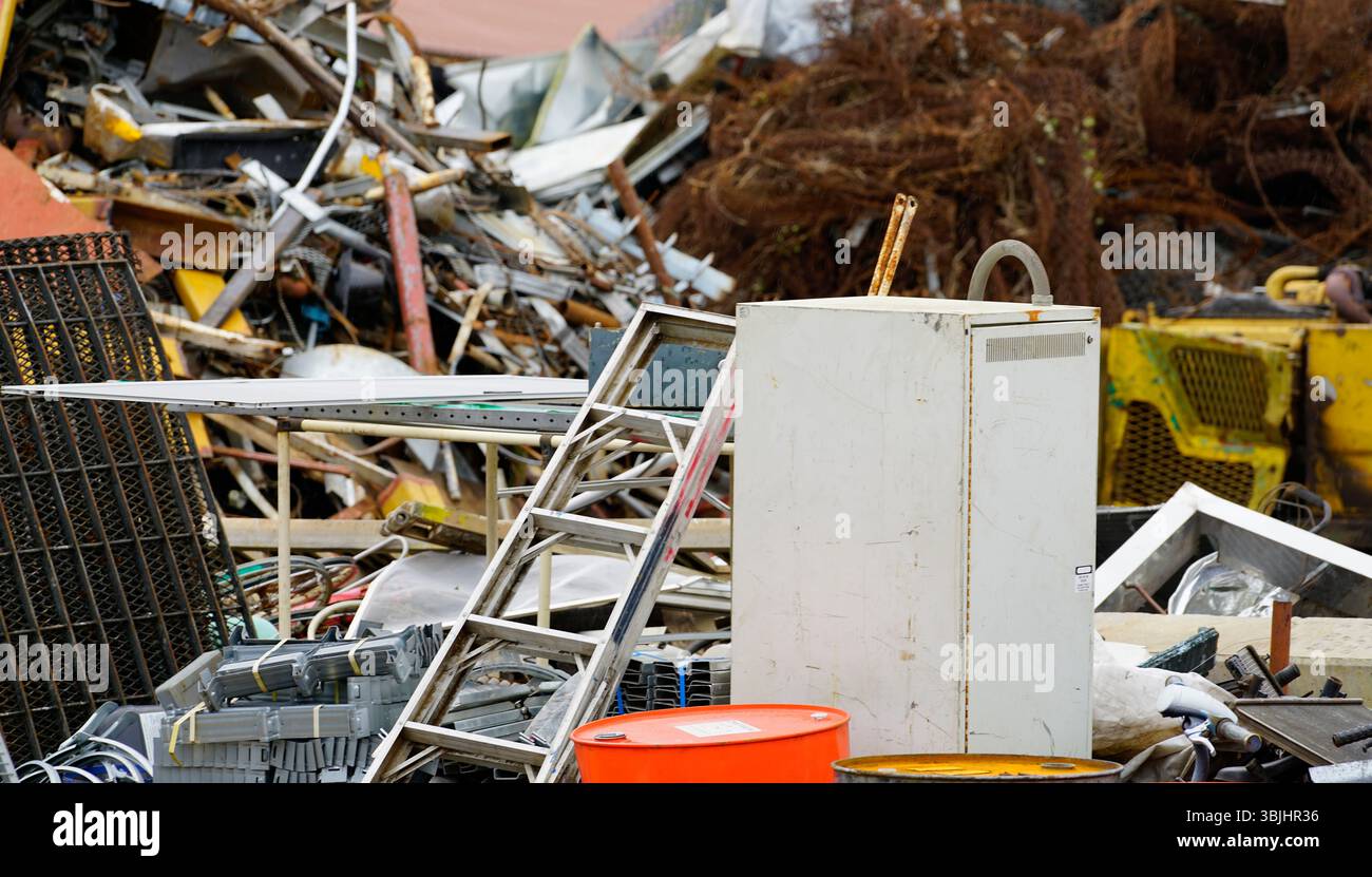 Pile di rottami metallici arrugginiti presso lo stabilimento di riciclaggio, dove i concessionari raccolgono e trattano materiali in ferro e acciaio scartati per una produzione sostenibile Foto Stock