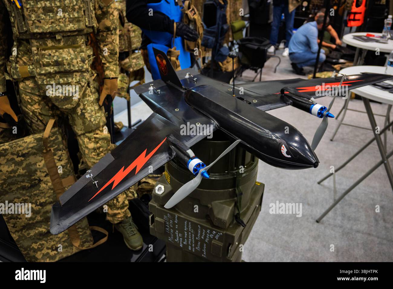 Drone nero ad ala fissa con design con bullone lampo rosso per applicazioni militari o ricreative in ambienti interni. Foto Stock