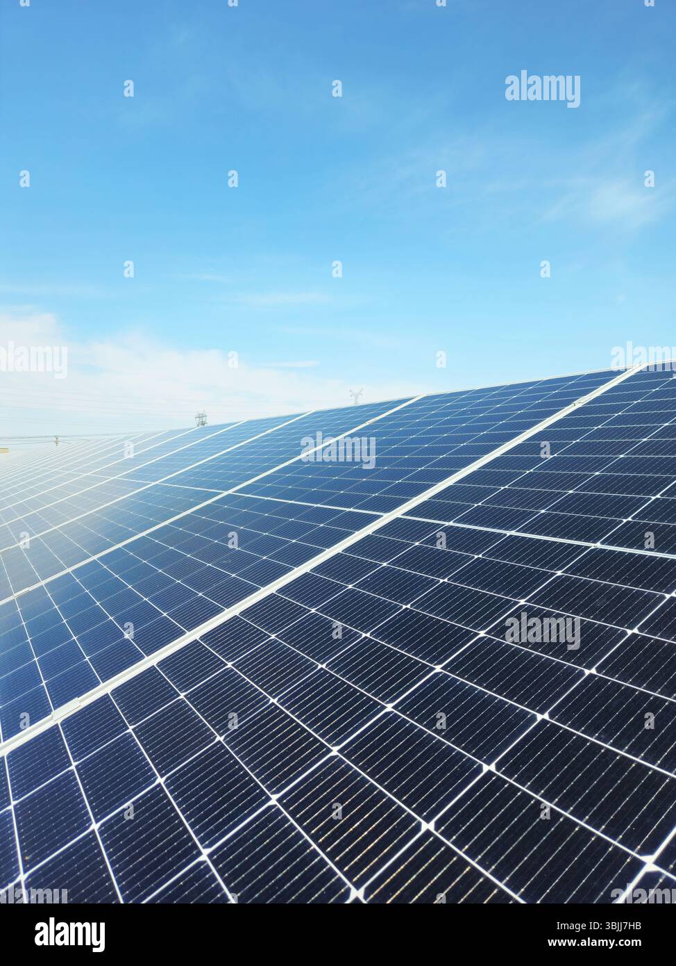 Array di pannelli solari in scala utility, linee di energia pulita sotto Clear Sky Foto Stock