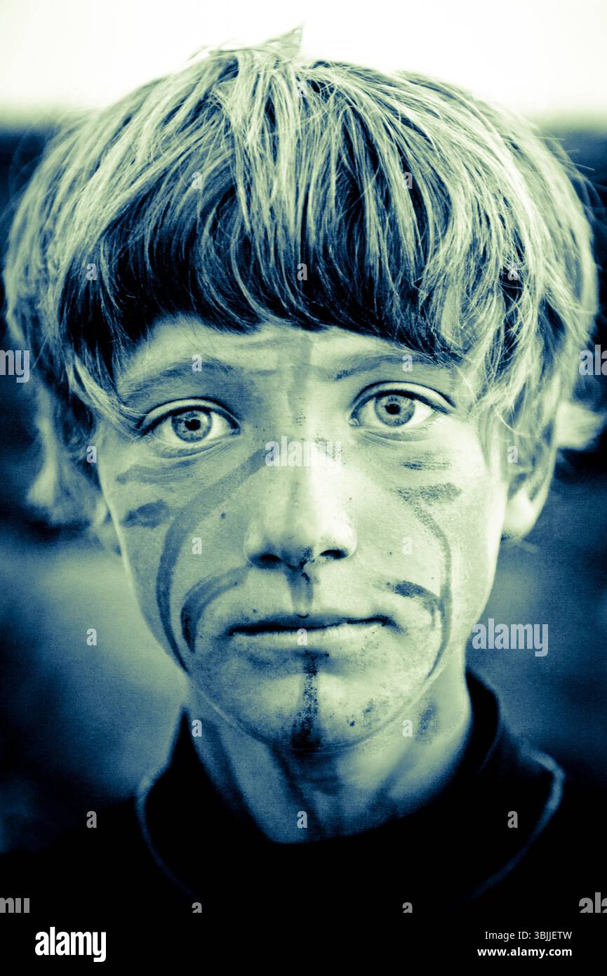 un ragazzo con il volto tribale gioca con i suoi amici Foto Stock