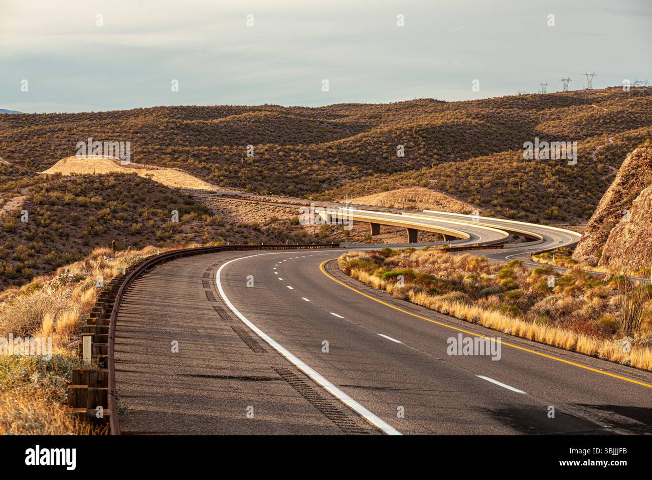 Carreggiata curva e ponte in un ambiente desertico remoto Foto Stock