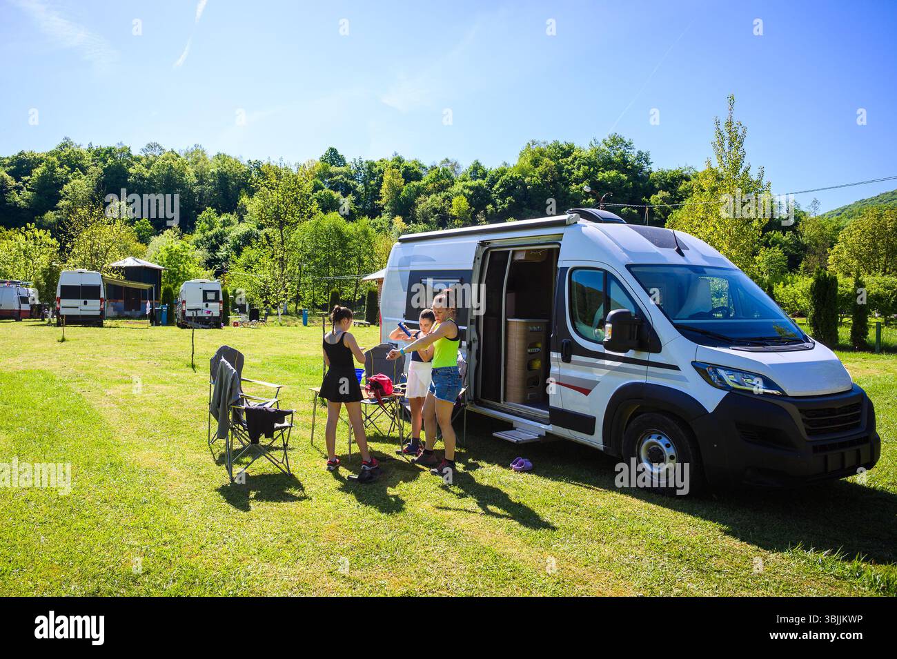 Campeggio per famiglie con camper in un campeggio in Bosnia vicino al fiume una. Relax per tutta la famiglia con camper, sedie e tavolo in vacanza, prendendo il sole Foto Stock