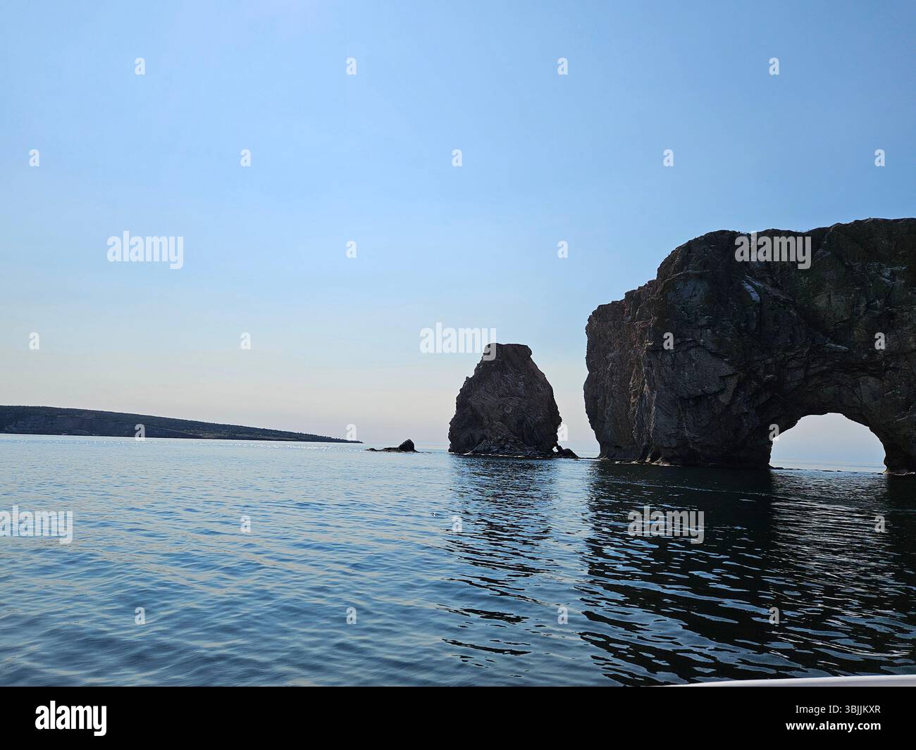La formazione naturale di archi rocciosi sopra le calme acque blu con la macchia del mare crea un paesaggio costiero mozzafiato e meraviglia geologica Foto Stock