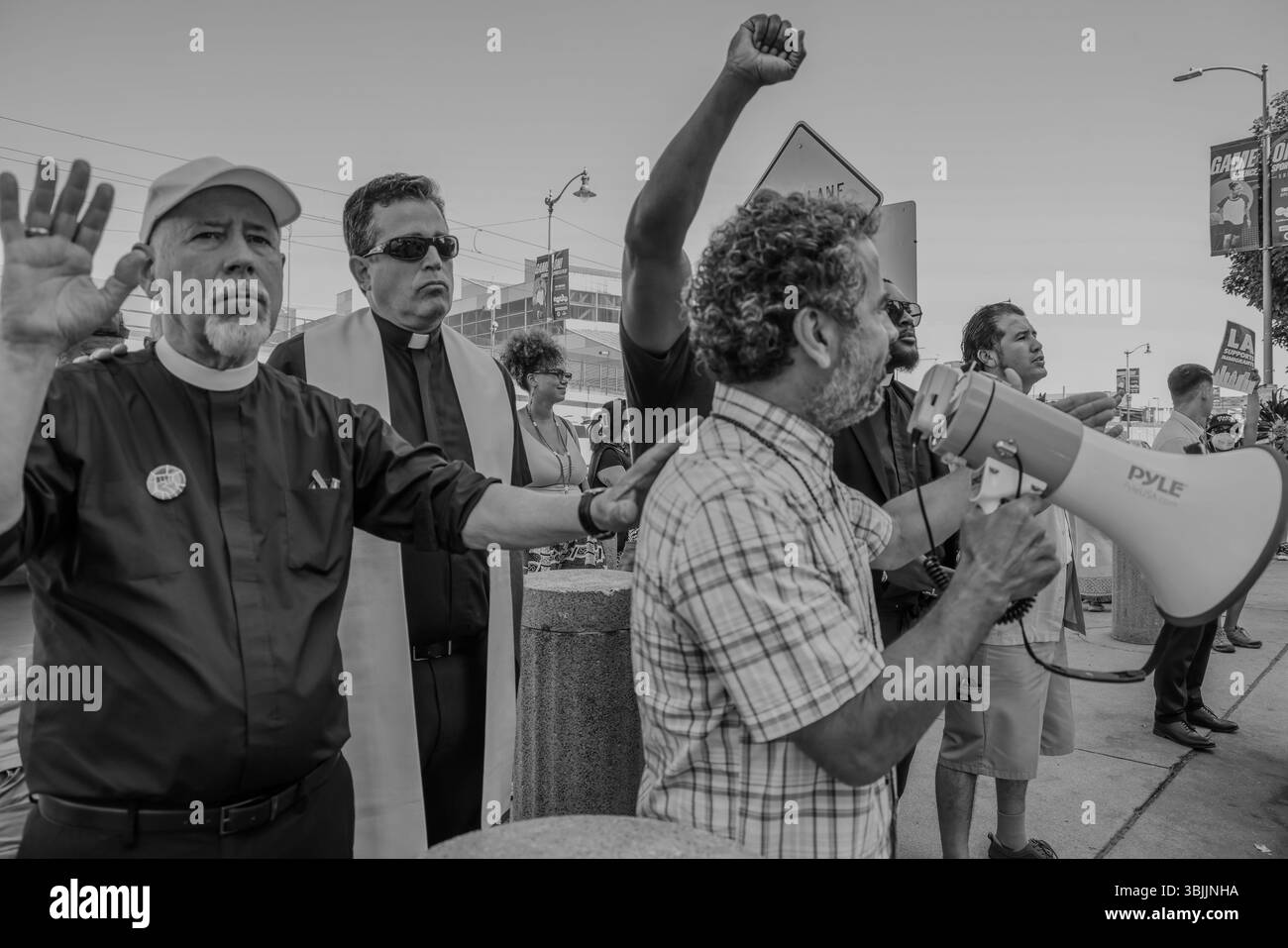 Los Angeles, California, Stati Uniti. 15 giugno 2025. Guillermo Torres, Clergy & Laity United for Economic Justice (INDIZIO) fa parte della Summer of Resistance Coalition, che ha realizzato e consegnato le carte del giorno del padre per i detenuti immigrati al Fed Building di LOS ANGELES il giorno 3 dell'azione di 30 giorni guidata da CLUE: Clergy and Laity United for Economic Justice. Indizi i leader interreligiosi hanno tenuto una processione sacra per la Festa del papà negli edifici federali e nel centro di detenzione nel centro di LOS ANGELES e hanno consegnato i biglietti per la Festa del papà ai Marines nella speranza che li passino ai detenuti nell'edificio dietro di loro. Ma la mamma Foto Stock