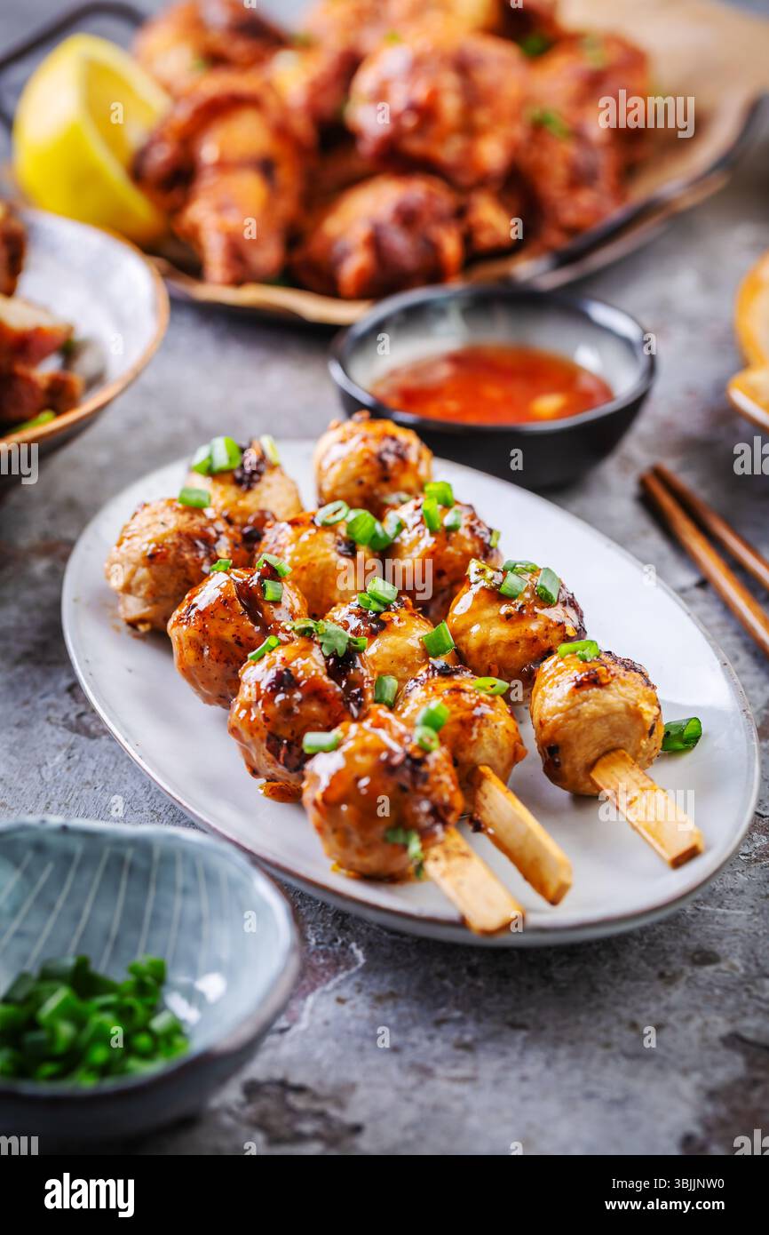 Assortimento di Street food asiatici, frittura in padella con verdure, ali di pollo, polpette di carne e riso Foto Stock