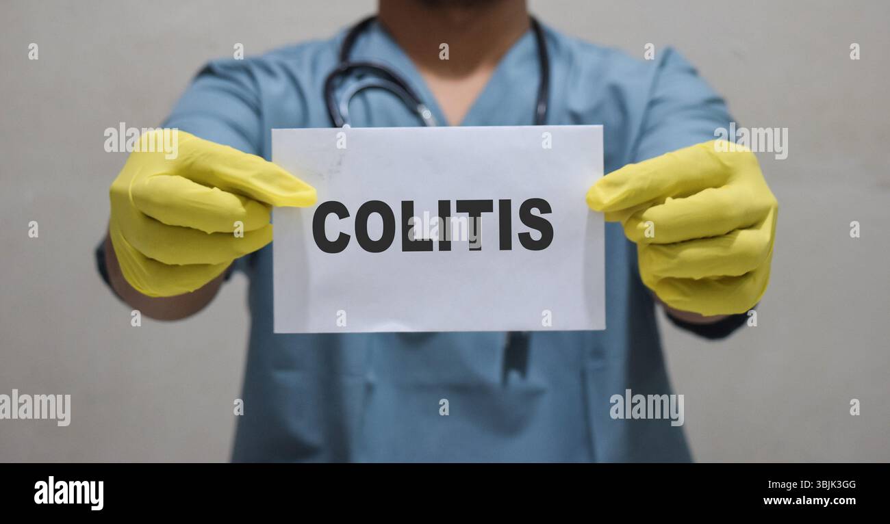 Il medico tiene in mano una scheda con il testo colite. Concetto medico Foto Stock