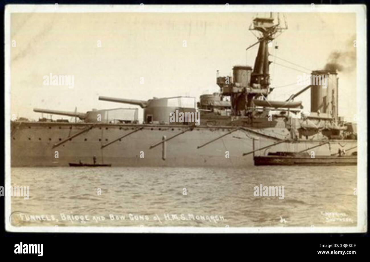 Questa cartolina, fotografata da Ernest Hopkins, raffigura gli imbuti, il ponte e i cannoni di prua della HMS Monarch della Royal Navy, illustrando le caratteristiche principali della nave e l'artiglieria navale all'inizio del XX secolo. Foto Stock