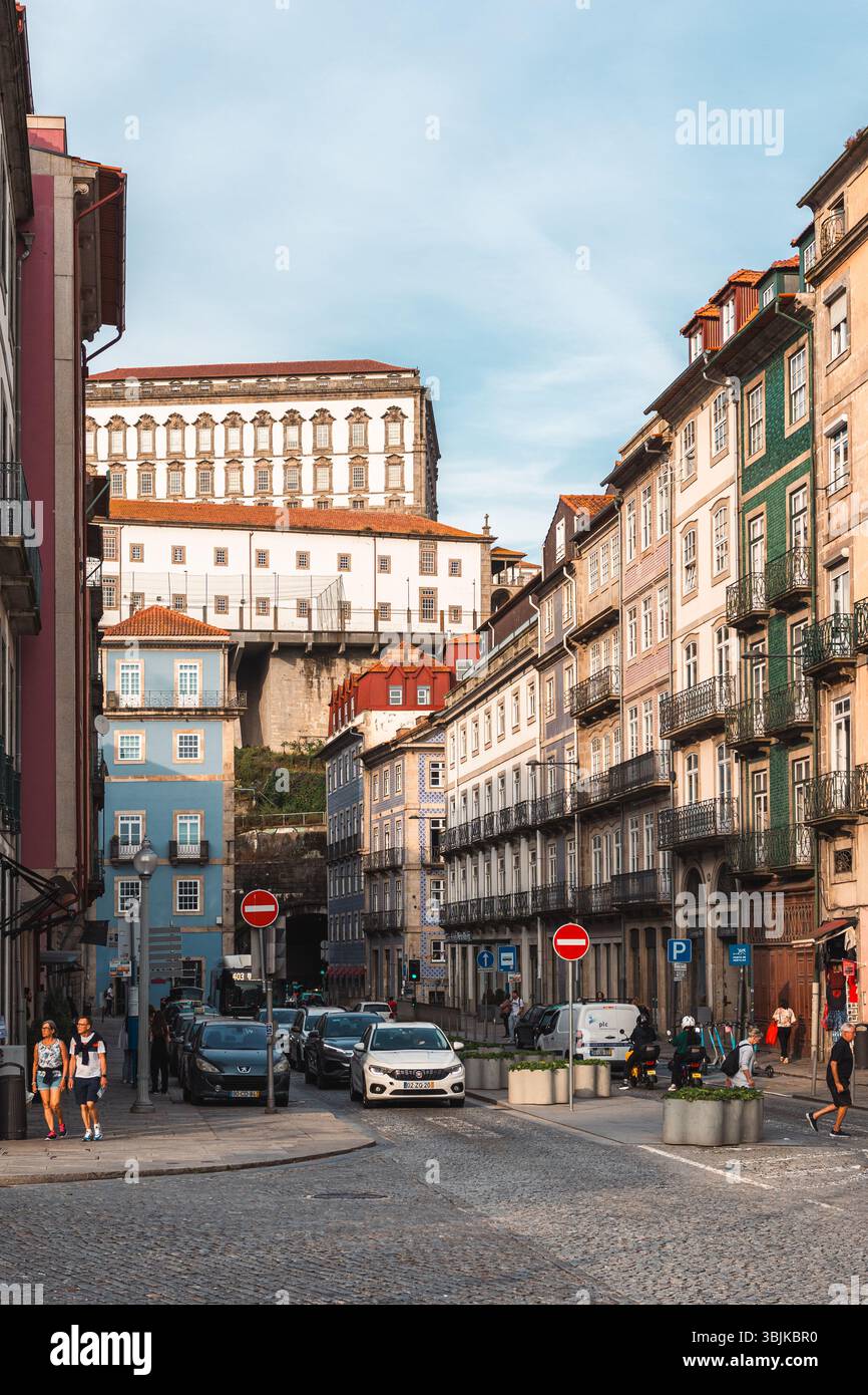 Vivace scena di strada della città di Lisbona con edifici tradizionali colorati, pedoni e auto, che catturano la vita quotidiana della città. Lisbona, Portogallo - 9 giugno 2025 Foto Stock