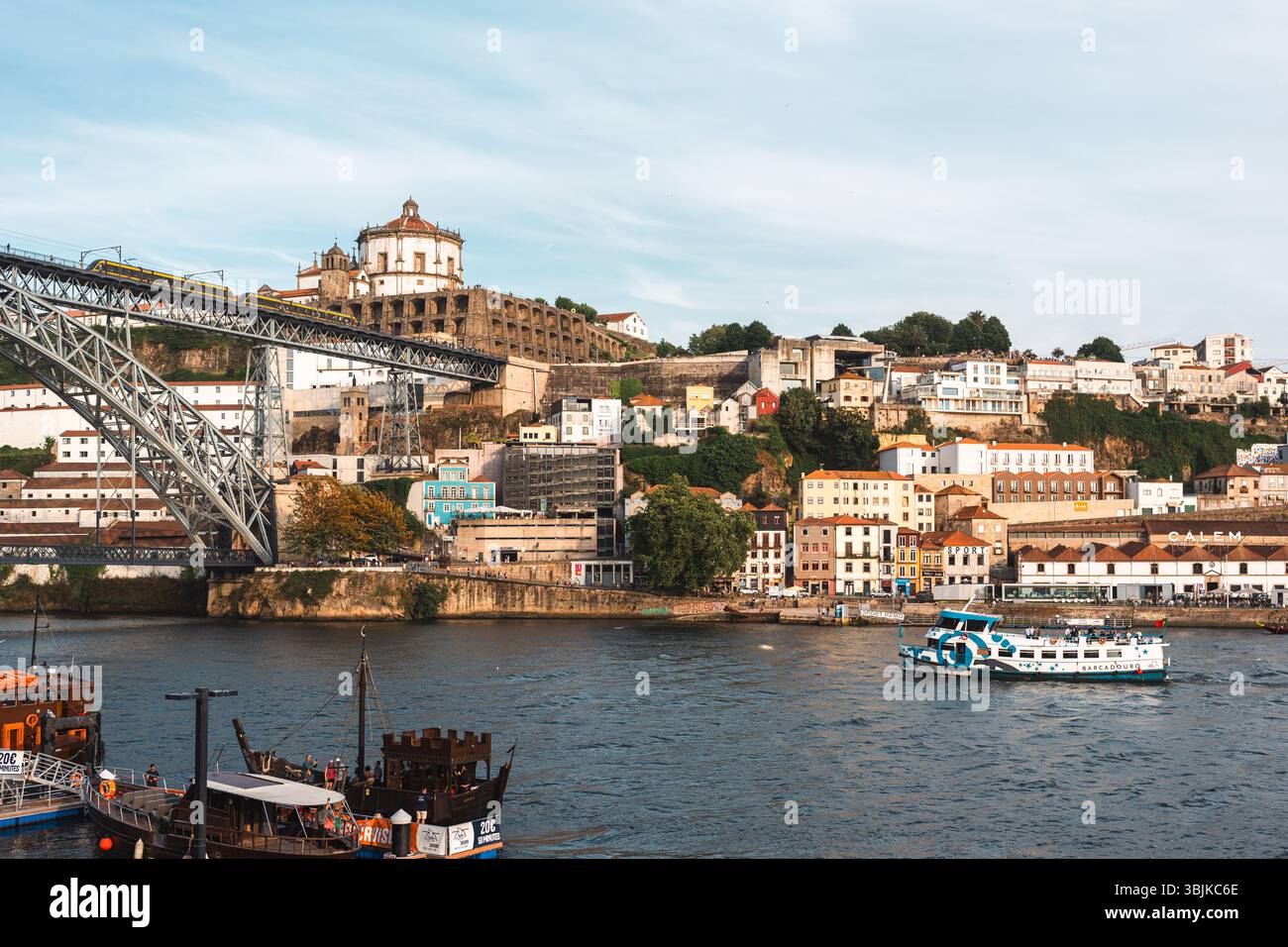 Vista panoramica del quartiere di Porto Ribeira con l'iconico Ponte Dom Luis i e le barche da crociera sul fiume, perfette per ispirarsi al viaggio. Porto, Portogallo - 11 giugno 2025 Foto Stock