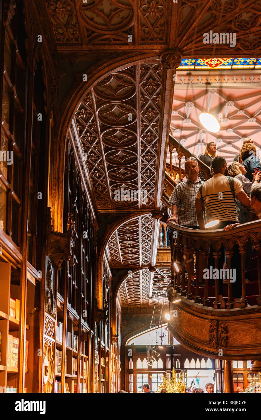 I visitatori potranno ammirare le intricate lavorazioni in legno e il soffitto in vetro colorato all'interno della famosa libreria Livraria Lello di Porto, Portogallo - 11 giugno 2025 Foto Stock