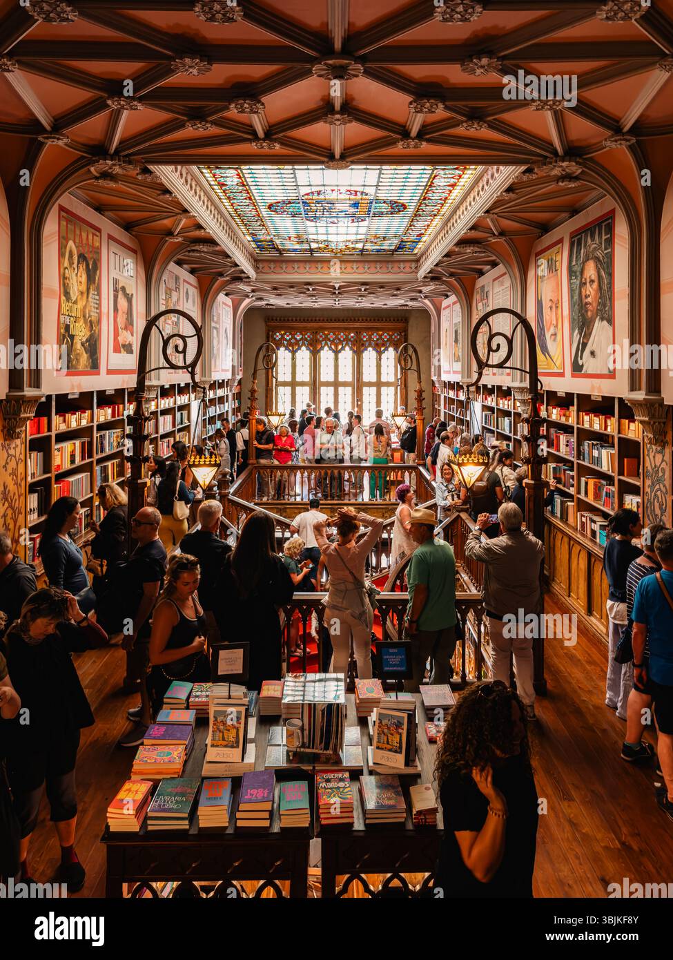 I turisti esplorano una famosa libreria architettonica, piena di libri e di vivaci vetrate colorate. Porto, Portogallo - 11 giugno 2025 Foto Stock