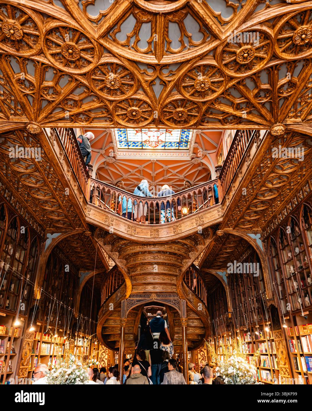I visitatori potranno ammirare l'intricata architettura in legno e il soffitto in vetro colorato della famosa libreria Livraria Lello di Porto, Portogallo - 11 giugno 2025 Foto Stock